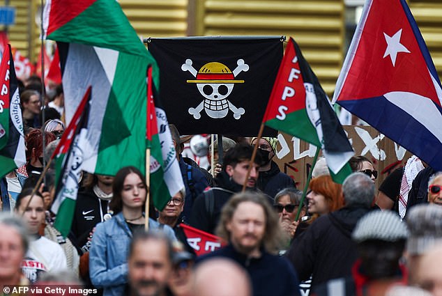 Protestors hold One Piece and other flags during a social justice rally in Lille, northern France
