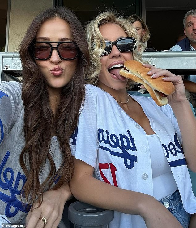She also nibbled on a hot dog while sitting in the stands and struck a suggestive pose before chowing down on the meal with her former Immaculate co-star Kaylee McGregor