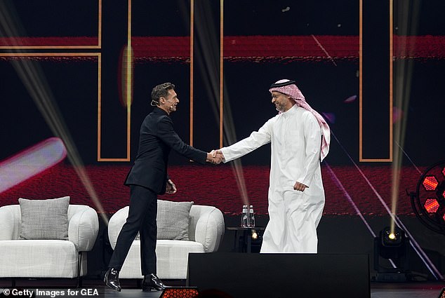 Seacrest and Faisal Bafarat speak shake hands on stage