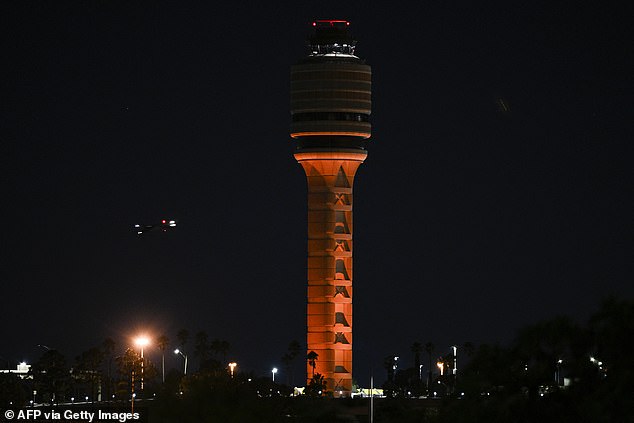 The air traffic control tower is seen at Orlando International Airport in Orlando, Florida early morning on October 31, 2025. Flights at Orlando International Airport faced major delays on October 30, after the Federal Aviation Administration (FAA) said the airport had no certified air-traffic controllers in its tower, forcing arrivals to be halted or severely delayed amid the ongoing US government shutdown. Air traffic controllers -- seen as "essential" public servants -- are kept at work during government shutdowns, but higher numbers are calling in sick rather than toiling without pay, leading to shortages. (Photo by Miguel J. Rodriguez Carrillo / AFP) (Photo by MIGUEL J. RODRIGUEZ CARRILLO/AFP via Getty Images)