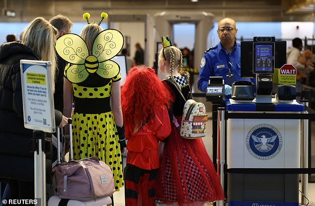 Young passengers dressed up for Halloween stand at a TSA checkpoint at Ronald Reagan Washington National Airport during the government shutdown, in Arlington, Virginia, U.S., October 31, 2025. REUTERS/Kevin Lamarque