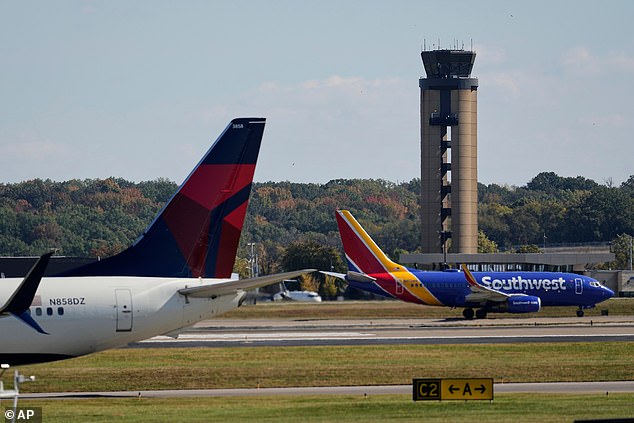 Planes taxi past the control tower before takeoff at the Nashville International Airport, Friday, Oct. 31, 2025, in Nashville, Tenn. (AP Photo/George Walker IV)