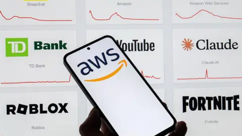 Getty An AWS logo on a phone screen with other logos behind it.