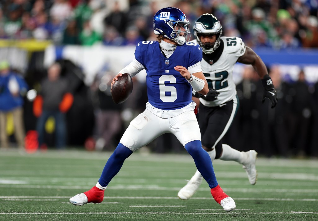 Jaxson Dart #6 of the New York Giants looks to pass as Za'Darius Smith #52 of the Philadelphia Eagles chases during the second quarter of the game at MetLife Stadium on October 9, 2025 in East Rutherford, New Jersey.