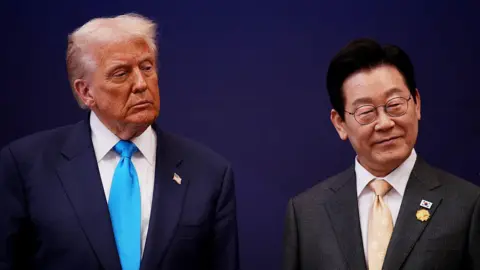 Getty Images U.S. President Donald Trump smiles as he stands next to South Korean President Lee Jae Myung
