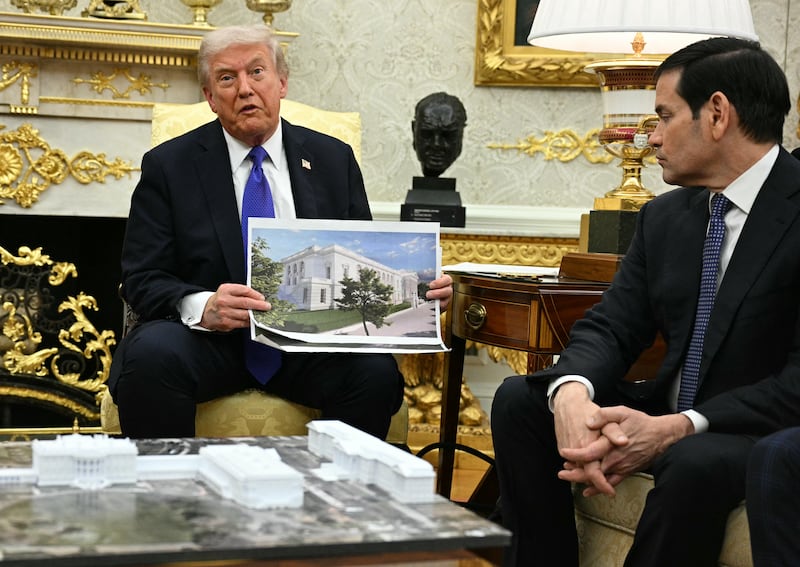 US President Donald Trump shows a rendition of the East Wing of the White House currently being demolished to build a ballroom as he meets with NATO Secretary General Mark Rutte in the Oval Office of the White House in Washington, DC, on October 22, 2025. (Photo by Jim WATSON / AFP) (Photo by JIM WATSON/AFP via Getty Images)