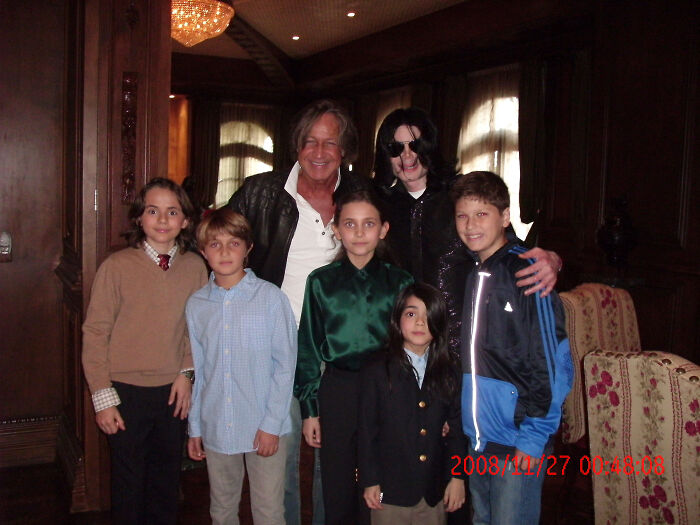 Michael Jackson with children and adult in a dimly lit room, related to Paris Jackson estate claims family turmoil.
