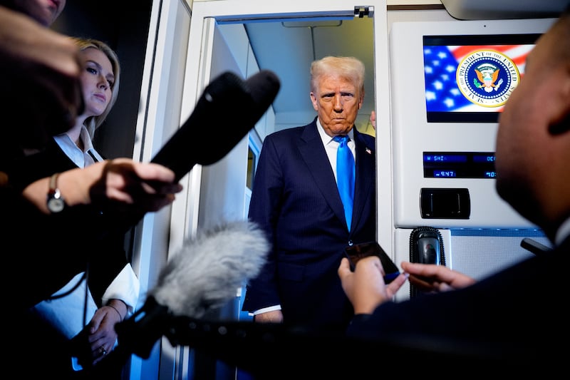President Donald Trump speaks to journalists aboard Air Force One en route to South Korea