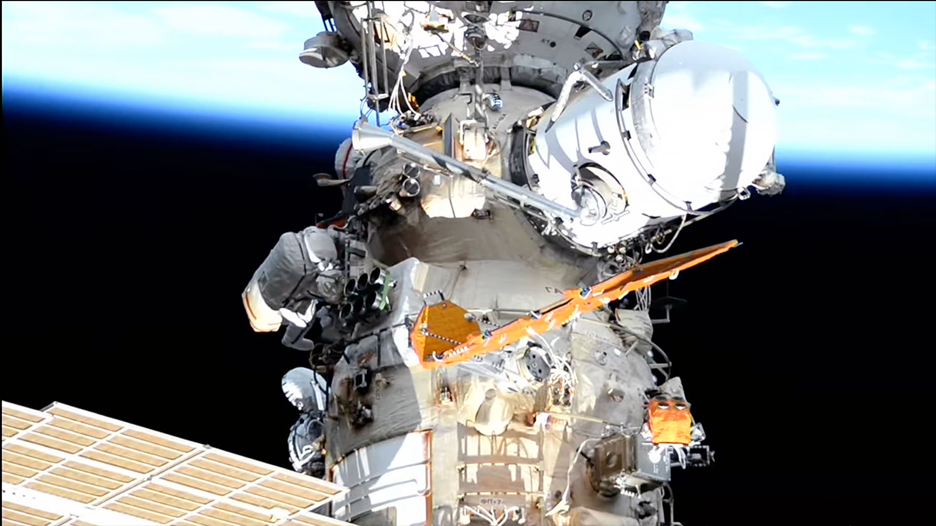 a look at a segment of a space station set against a backdrop of Earth and the blackness of space