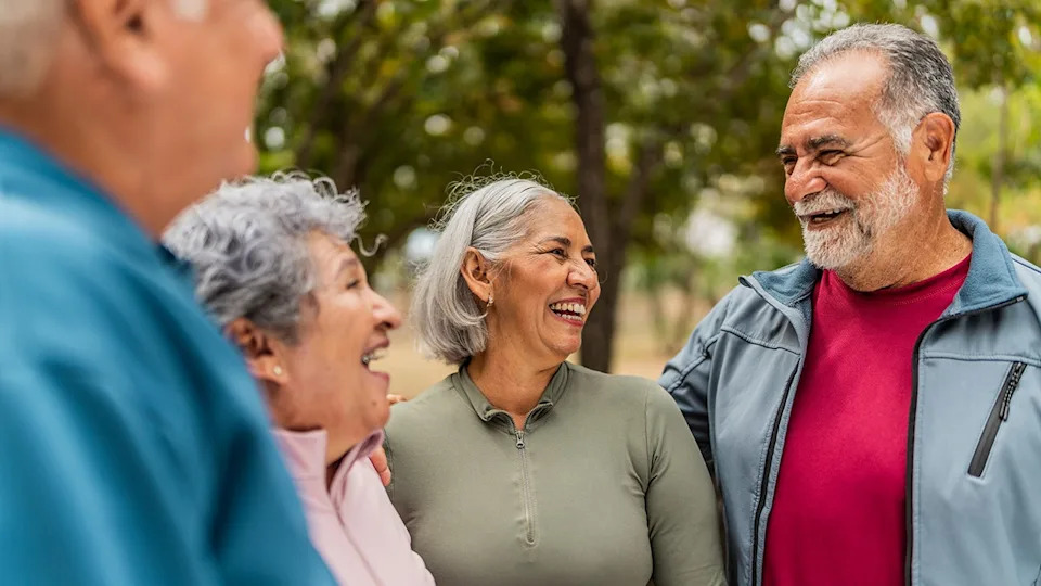 four senior friends talk and laugh