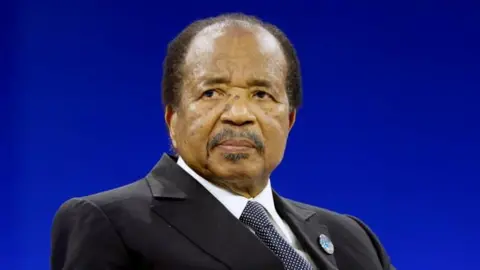 Reuters Paul Biya, wearing a suit, is seen sitting