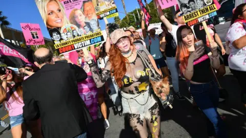 Michael Buckner via Getty Images Fans of Britney Spears are holding signs and that read "FREE BRITNEY".