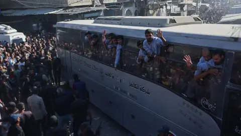 AFP via Getty Images Freed palestinians wave at crowds in Khan Younis. 