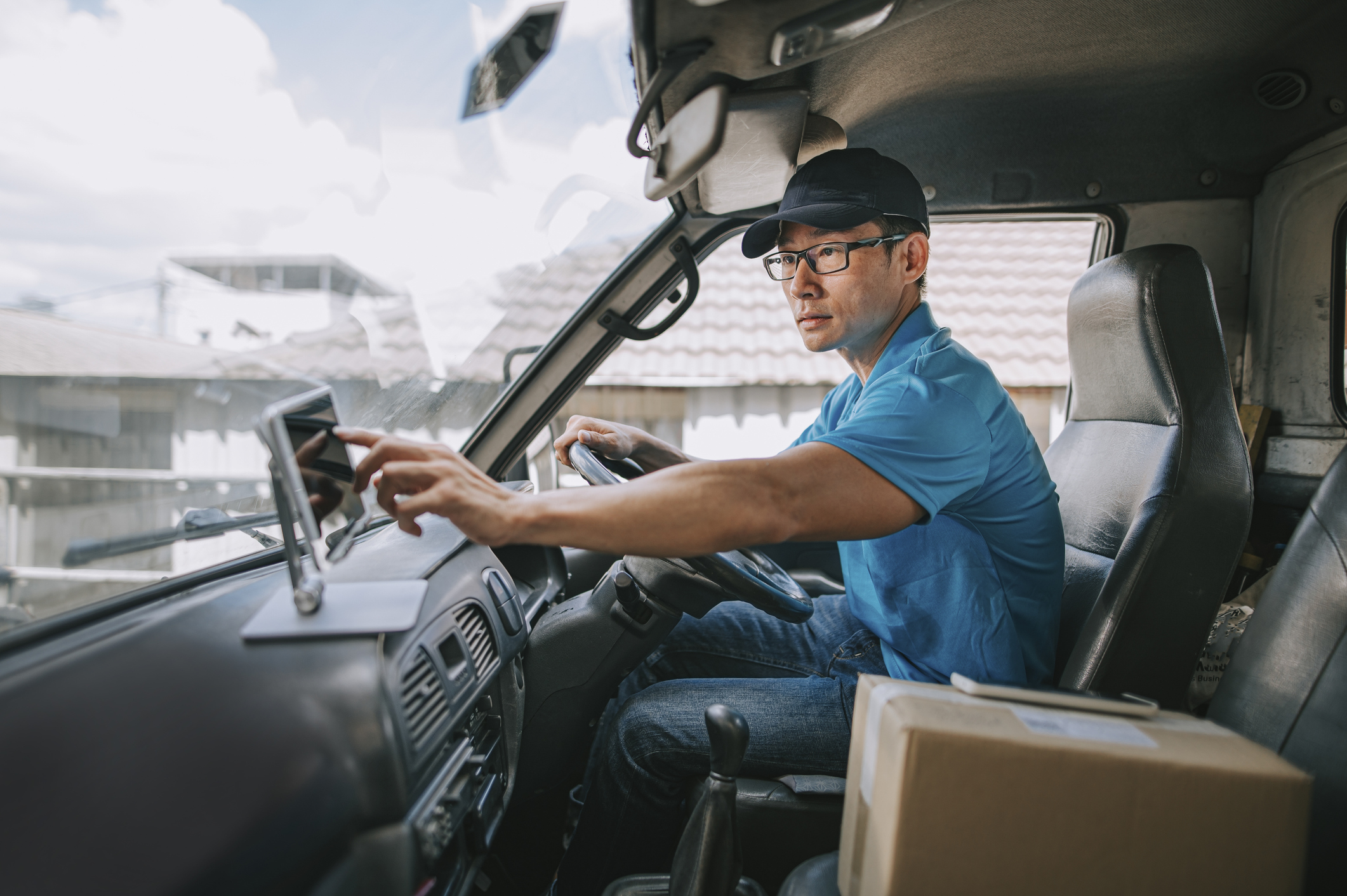 An Amazon delivery driver touching the dashboard inside a truck.