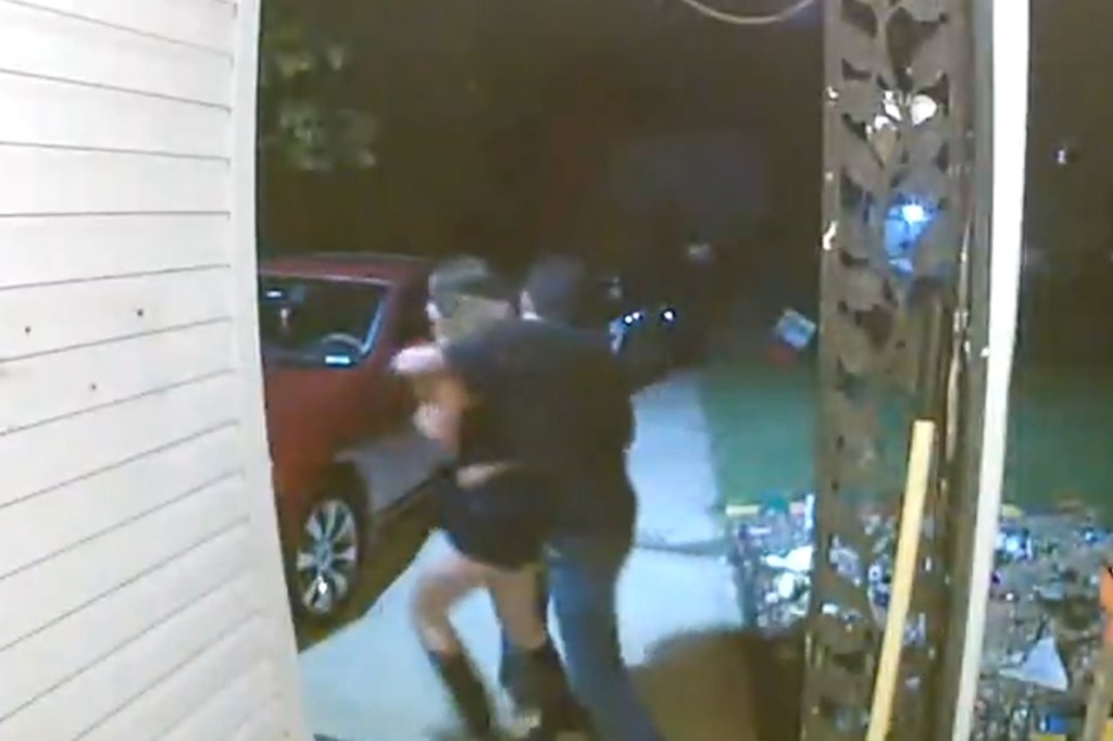Video still of a man pulling a woman near a red car.
