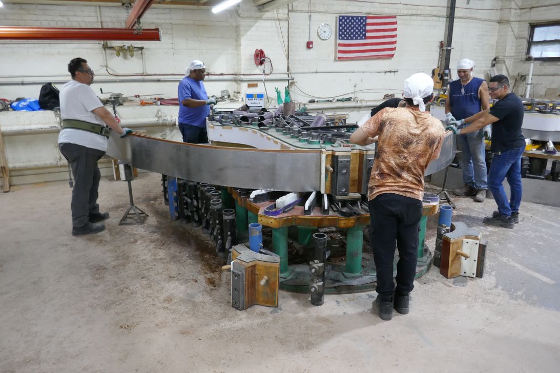 Craftsmen bend wood into shape for a piano frame at the Steinway & Sons factory in Queens, New York, on September 4, 2025.
