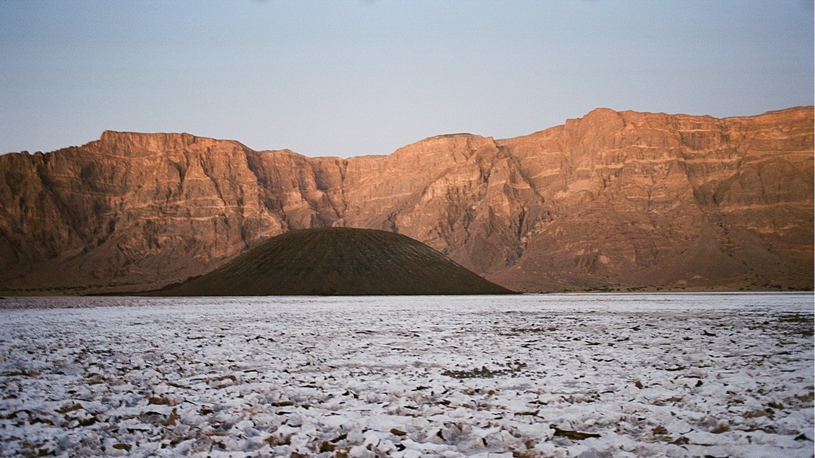 A photo of one of the cinder cones surrounded by natron, taken from ground level