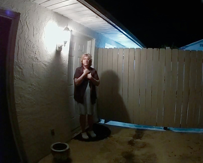 Woman standing at night outside a home in a dimly lit yard, scene related to Netflix’s The Perfect Neighbor true story.