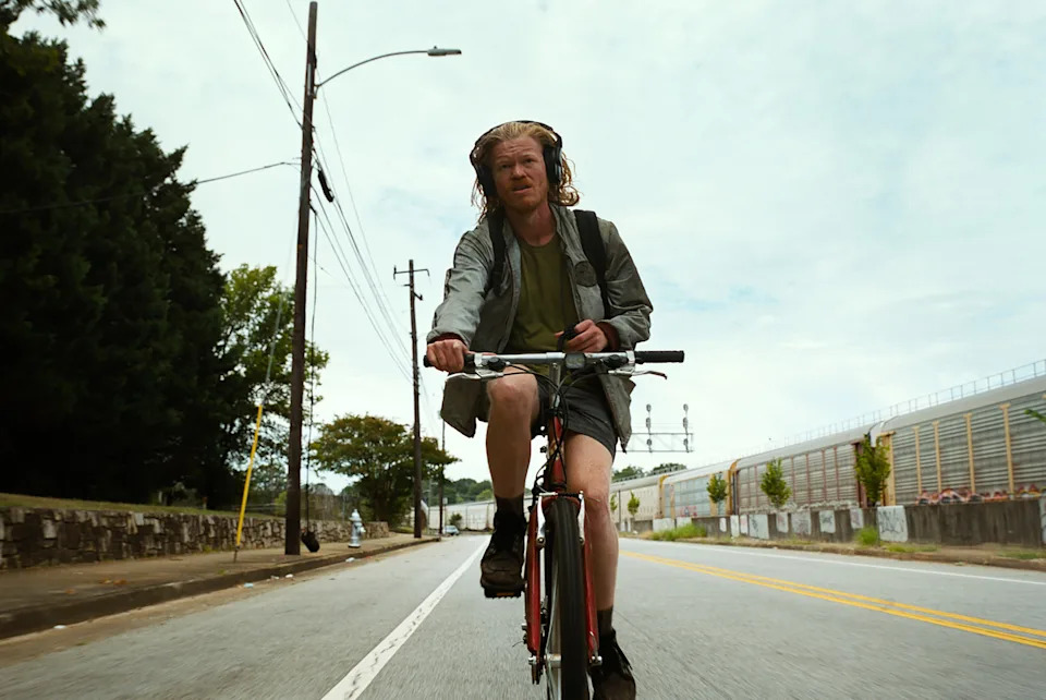 Jesse Plemons riding a bike in Bugonia.