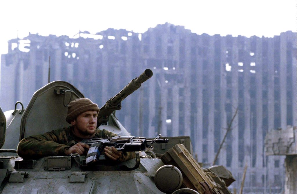 Photo: A member of the Russian special forces looks from an APC in front of the demolished presidential palace in rebel Chechen capital of Grozny on January 28. Credit: Reuters