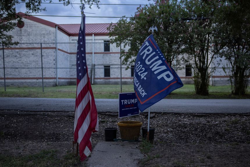 A Donald Trump 2024 campaign flag flies in the front yard of a private residence across the street from Federal Prison Camp Bryan on August 1.