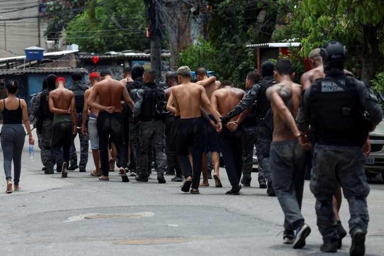 Members of the military police special unit detain suspected drug dealers during the operation in Complexa da Penha on October 28.