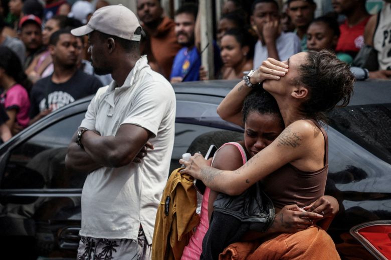 Mourners react as people gather around bodies October 29, the day after a deadly police operation against drug trafficking in Complexa da Penha.