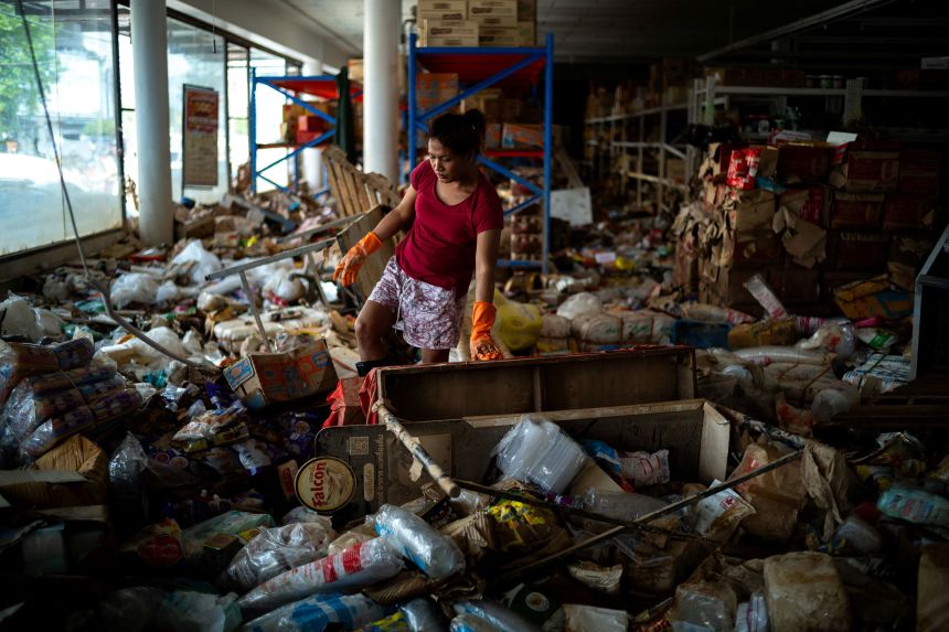 A woman cleans a wholesale store following deadly flooding in Hat Yai, in Thailand's Songkhla province, on November 29. REUTERS/Athit Perawongmetha