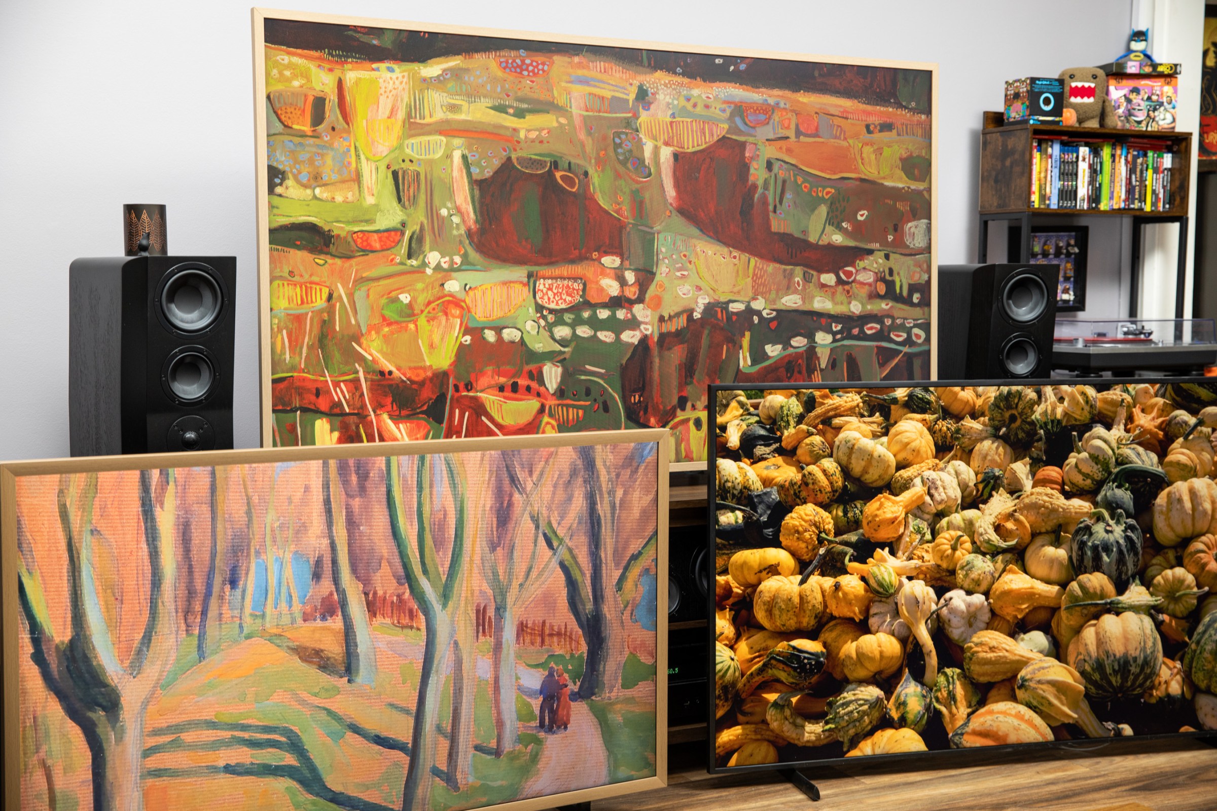 Samsung’s The Frame Pro, The Frame, and the Hisense CanvasTV set up in a living room displaying different pieces of art.