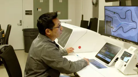 Sentante A man sitting in front of a computer looking at a scan.
