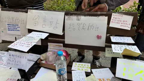 Ching Sze Yip/BBC Hand-written tributes On pieces of white paper