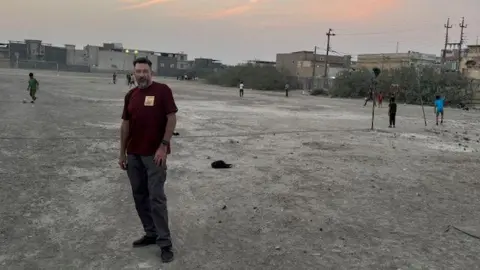 Ben Soppitt Ben Soppitt pictured with children playing football at the war grave site 