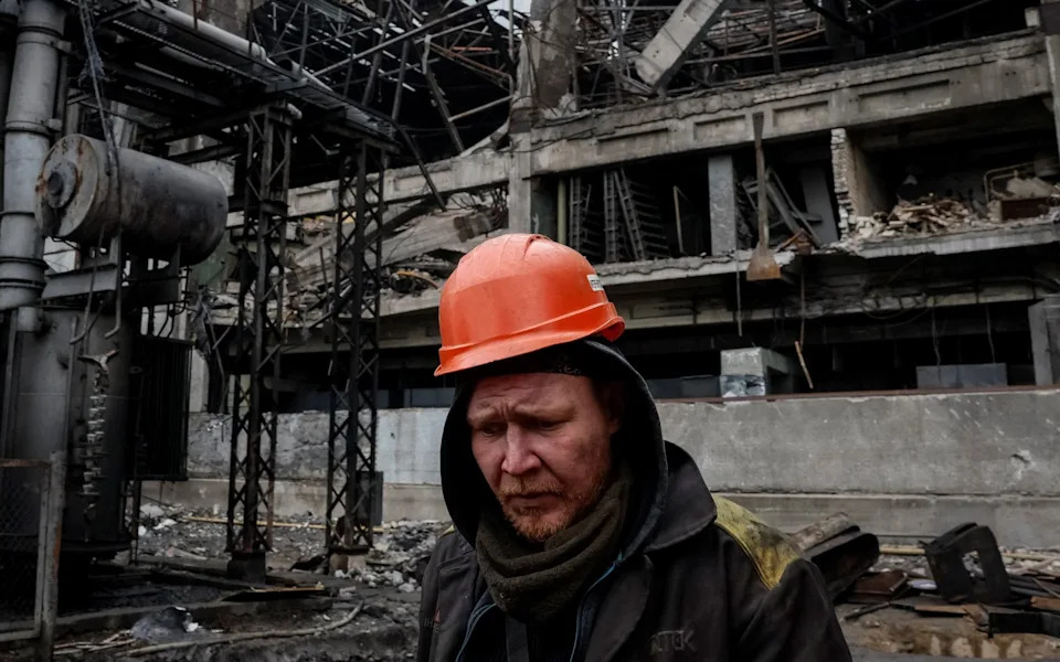 An employee inspects a thermal power plant hit in a recent Russian missile strike, at an undisclosed location in Ukraine on November 13
