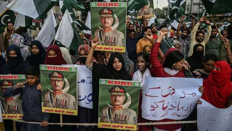 Getty Images Protesters hold Pakistan flags and posters of Field Marshal Munir during an anti-India protest in Karachi on 2 May 