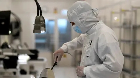 Reuters An employee works with a wafer in a production line of Dutch semiconductor company Nexperia, in Hamburg, Germany.