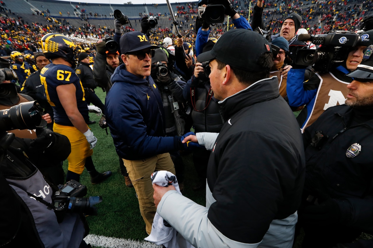 Michigan head coach Jim Harbaugh, left, shakes hands with Ohio State head coach Ryan Day after an NCAA college football game in Ann Arbor, Mich., Saturday, Nov. 30, 2019. Ohio State won 56-27.