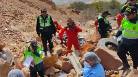 Public Prosecutor's Office Emergency workers clamber over boulders at the bottom of the ravine. 