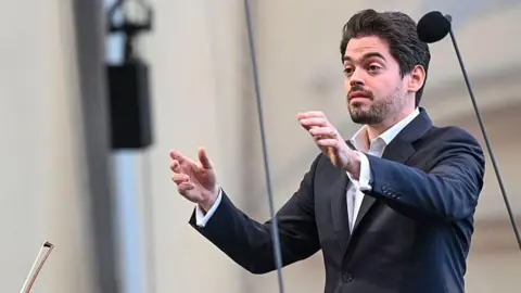 Hannes Magerstaedt/Getty Images File photo showing Israeli conductor Lahav Shani wearing a dark-coloured blazer and a white shirt