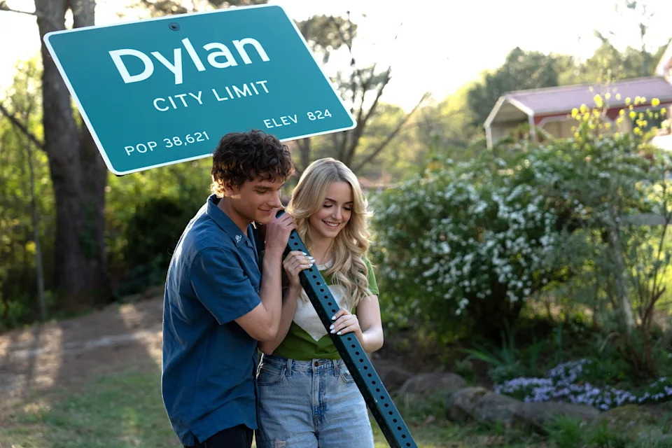 Mason Thames and Mckenna Grace holding a city limit sign that says Dylan.