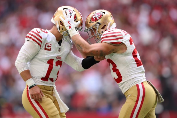 Brock Purdy #13 and Christian McCaffrey #23 of the San Francisco 49ers celebrate a touchdown against the Arizona Cardinals during the second quarter at State Farm Stadium on Nov. 16, 2025 in Glendale, Arizona. (Photo by Mike Christy/Getty Images)