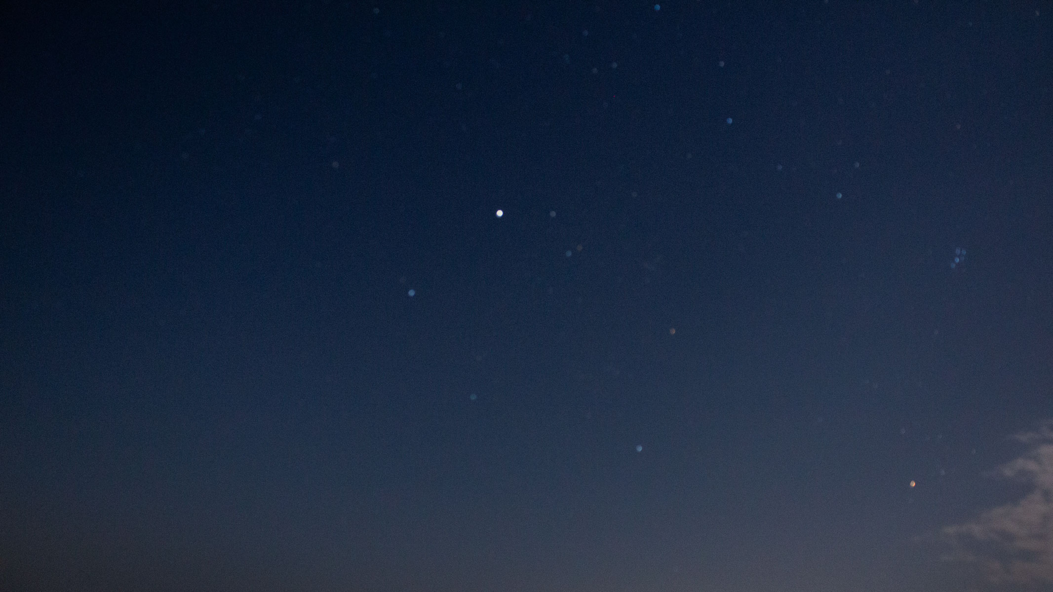 An out-of-focus image of Auriga, the Pleiades and Taurus in the starry night sky.