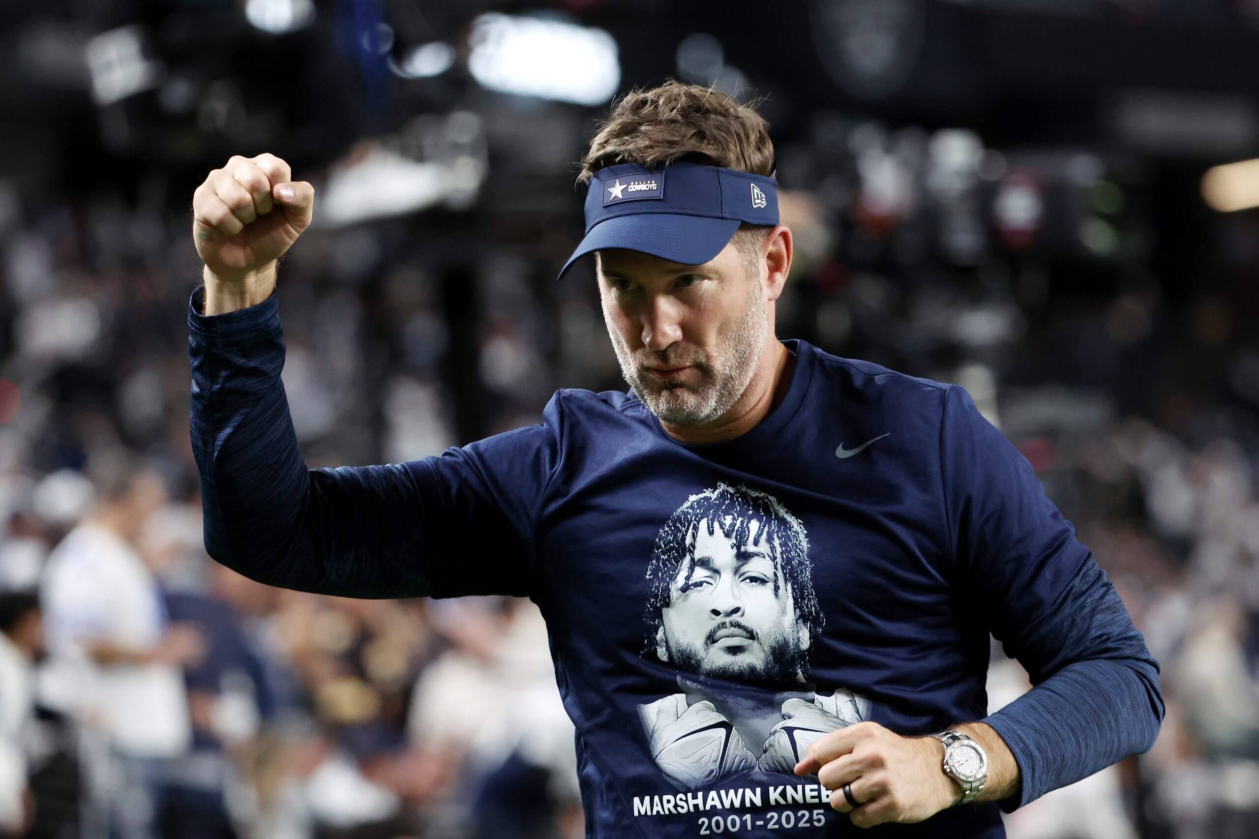 Cowboys coach Brian Schottenheimer, wearing a shirt honoring Marshawn Kneeland, reacts after his team beat the Raiders on Monday night. 