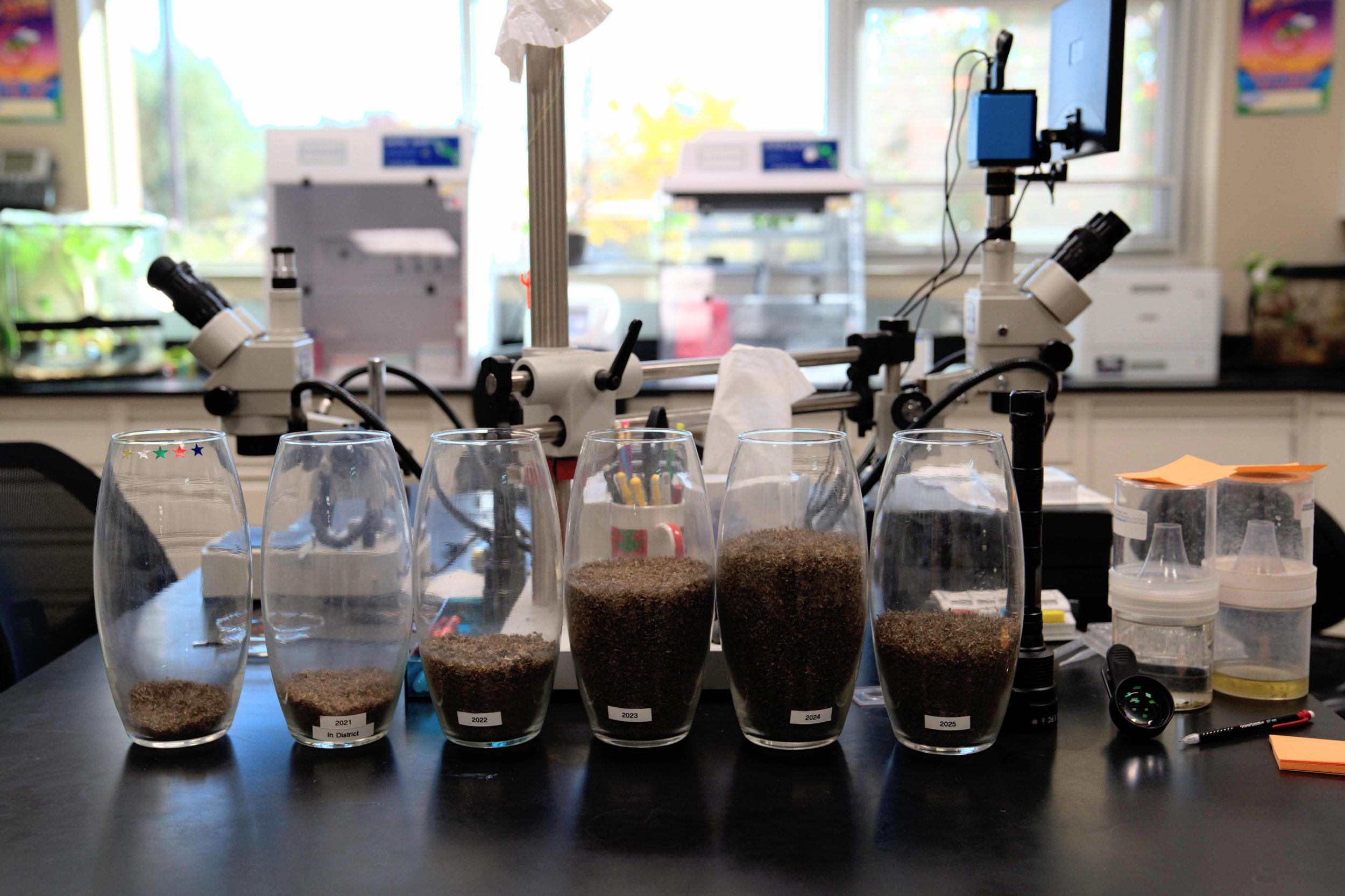 Containers, labeled by year, display the mosquitoes caught by the Grand River Mosquito Control District.