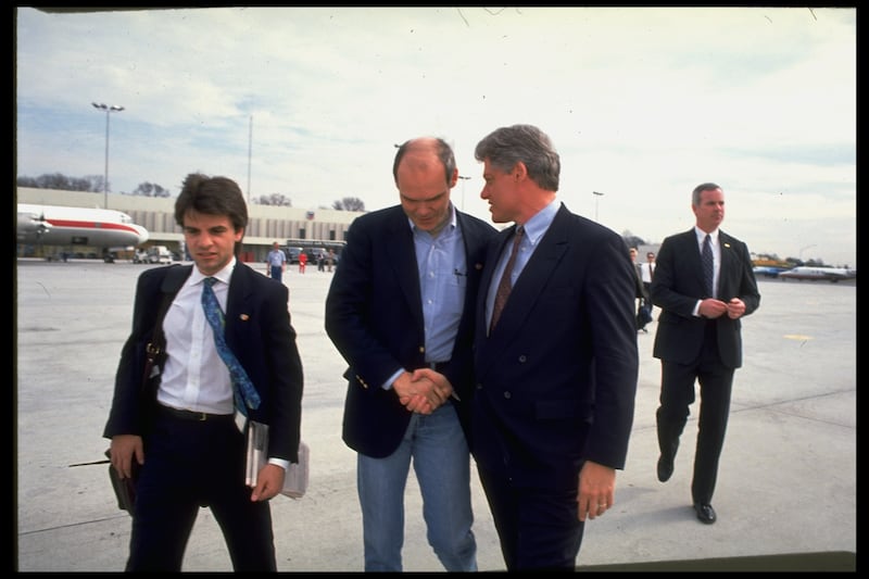 Bill Clinton walking airport tarmac with aides George Stephanopoulos and strategist James Carville.