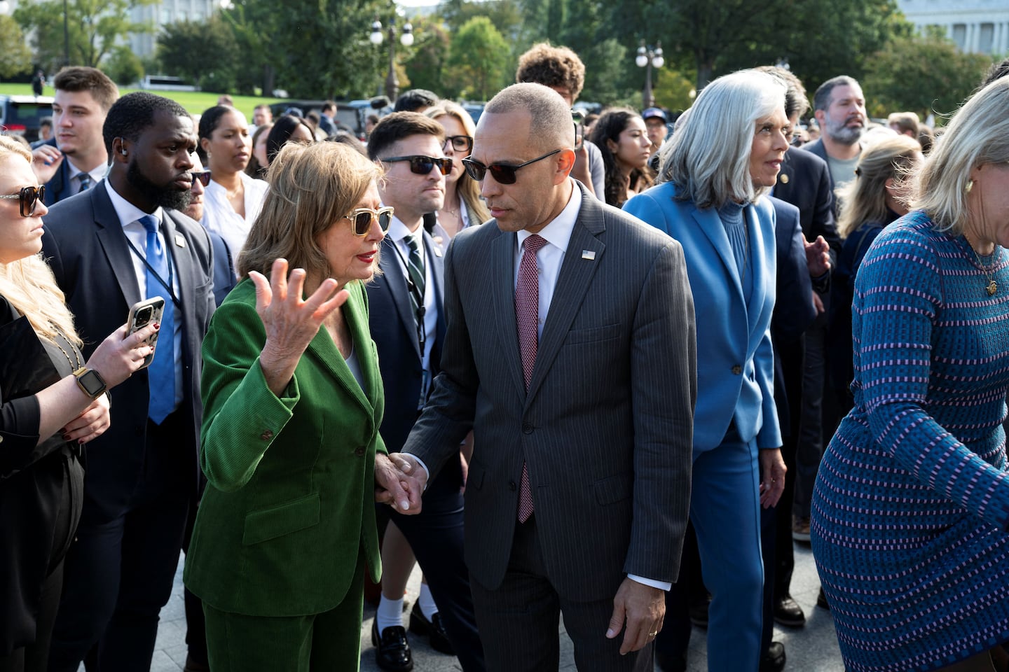 US House Minority Leader Hakeem Jeffries (C), Democrat of New York, speaks with Rep. Nancy Pelosi, Democrat of California, after a press conference on the steps of the US Capitol in Washington, DC.