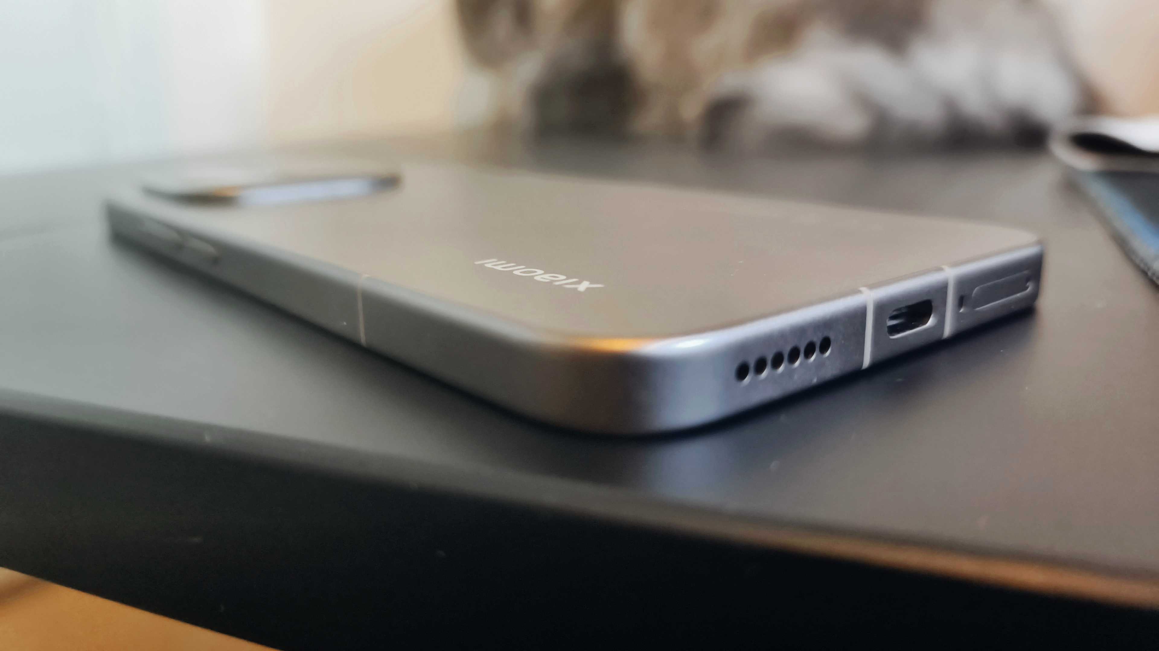 A mocha brown Xiaomi 15T Pro smartphone on a black desk