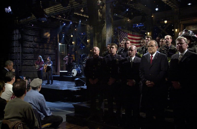 SATURDAY NIGHT LIVE -- Episode 1 -- Air Date 09/29/2001 -- Pictured: SATURDAY NIGHT LIVE -- Episode 1 -- Air Date 09/29/2001 -- Pictured: Paul Simon performs, members of the New York Fire Department, New York Police Department, Port Authority Police Department, with (center, l-r) Police Commissioner Bernard Kerik, Mayor Rudolph Guiliani, Fire Commissioner Tom Von Esses on September 29, 2001  (Photo by Dana Edelson/NBCU Photo Bank/NBCUniversal via Getty Images via Getty Images)