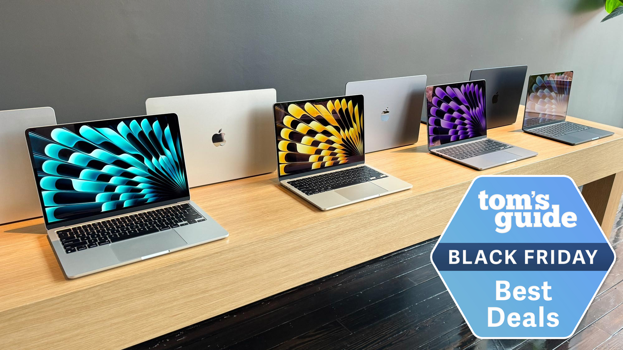 MacBook deals on a table with Black Friday best deals tag superimposed