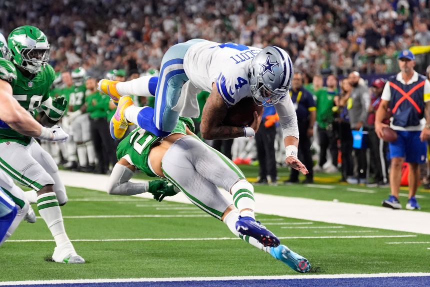 Dallas Cowboys quarterback Dak Prescott leaps over Philadelphia Eagles safety Sydney Brown for the tying score in the fourth quarter.