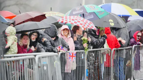 PA Media A crowd under umbrellas in Merthyr Tydfil for a visit by King Charles on his birthday